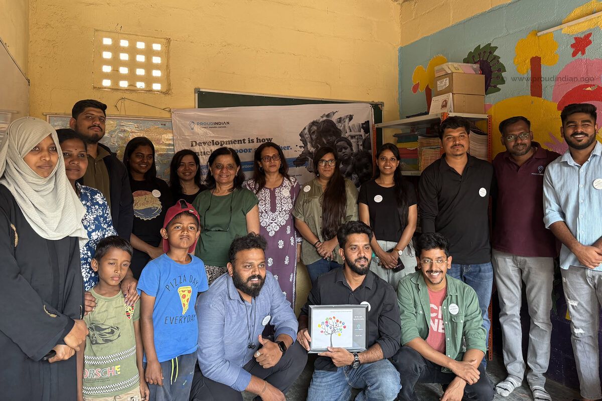 The Ethos team with children and Optimists at our community centre, holding up a framed painting