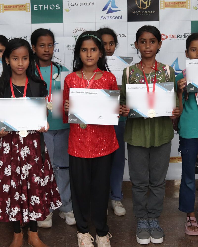 Children holding up their certificates and medals in front of the sponsors' board